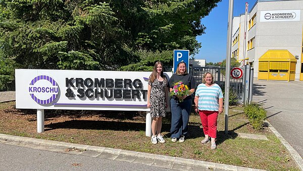 New JAV chairwoman with a bouquet of flowers and representatives from HR and the works council in front of the company premises.