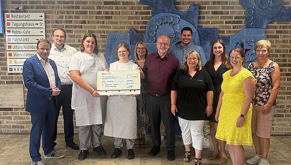 Kroschu employees and representatives of the BBW at the donation handover with a donation check.