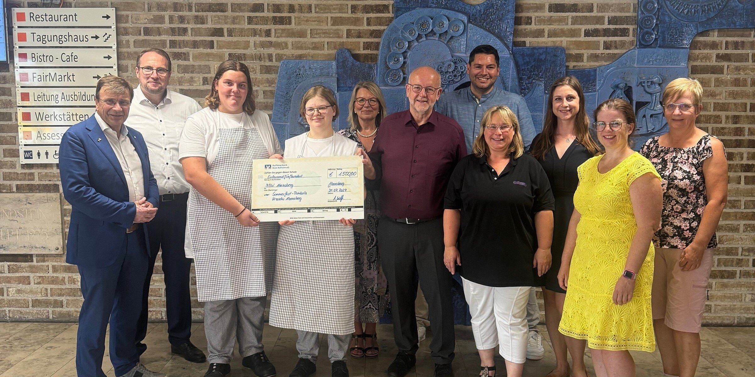 Kroschu employees and representatives of the BBW at the donation handover with a donation check.