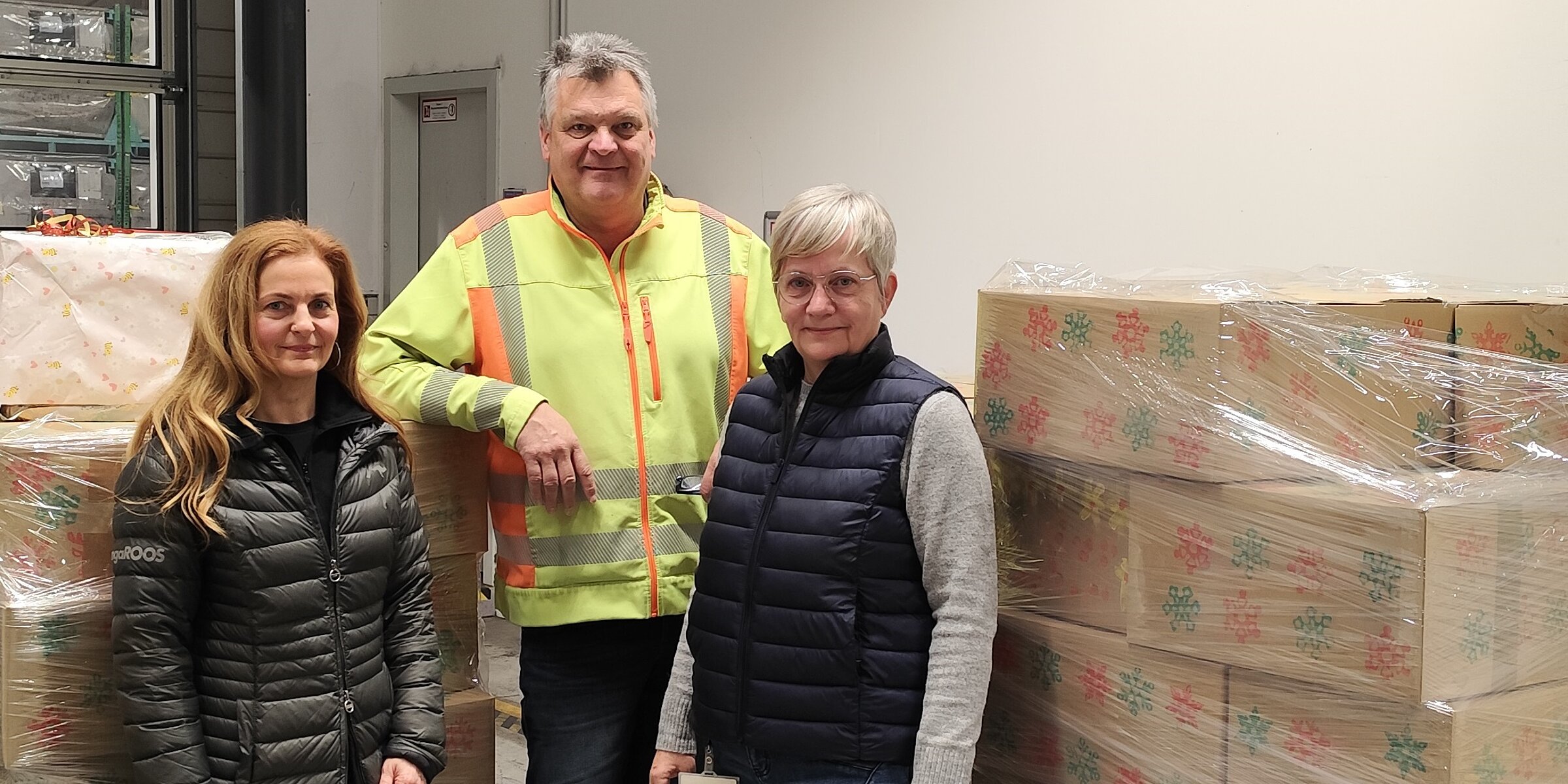 Representatives of the Kroschu works council and the Johanniter Christmas truckers in front of the packed pallets with the gifts.