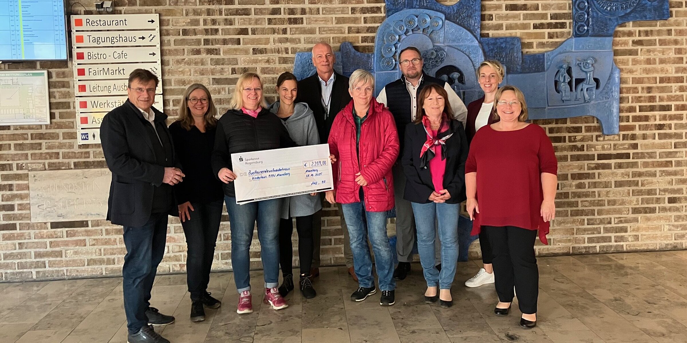 Representatives from Kroschu and the BBW with a large check at the donation handover
